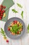 Top view salmon mix salad with sesame-honey dressing, slices of fish, cherry tomatoes, arugula, pickled cucumber, lunch menu of