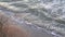 Top view of a sandy beach, sea waves crashing on the shore, sea foam.Beautiful soothing video, relaxation.Sea landscape, storming