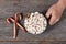 Top view of Santa Claus hand with a large mug of hot cocoa with marshmallows and cinnamon.