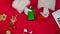 Top view Santa hands in white gloves uses smartphone with green screen chroma key by red New Year decorated table. Santa