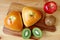 Top view of savory buns on wooden tray with apple and kiwi fruits