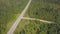 Top view scenic winding country road through green farmland. Clip. Aerial rural road countryside