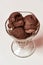 Top view of scoops of tasty chocolate ice cream in a glass sundae dish isolated over light background