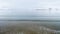 Top view of sea on background of coast in winter. Footage. Beautiful winter panorama of quiet blue sea on background of