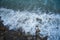 Top view of the sea wave and rocks. The water forms a whimsical pattern. Background, texture