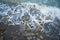 Top view of the sea wave and rocks. The water forms a whimsical pattern. Background, texture