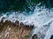 Top view of sea waves crashing of rocky coastline