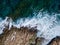 Top view of sea waves crashing of rocky coastline