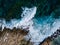 Top view of sea waves crashing of rocky coastline