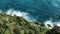 Top view of sea waves hitting coastline on the beach with turquoise blue sea water. green trees on cliff seascape in Atlantic