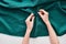 Top view of seamstress sewing colorful fabric with needle on white background.