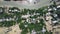 Top view of shore buildings surrounded by lush trees and mud flats at a beach