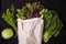 Top view shot of cabbage, leafy vegetables, and an eco bag isolated on dark background