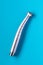 Top view shot of a dental high-speed handpiece on the blue background