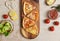 Top view shot various kinds of delicious tasty juicy thin crispy cheesy sliced Italian pizza placed on wooden cutting board on