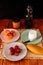 Top view shot of wine bottle, rice, bread, strawberries, and peaches on a wooden table