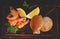Top view of shrimps and scallops in shells on a dark board before cooking