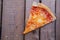 Top view of a slice of homemade pizza on a wooden table