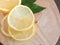 Top view slice lemon fruit with leaves on cutting board.