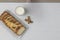 Top view of a sliced walnut bread on a glass plate with a glass of milk