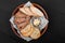 Top view of sliced wholegrain bread, ciabatta and rye spikelets bread with butter on black wooden background. Bakery products.