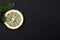 Top view of sliced yellow lemon with leaves of fresh lemon balm on black background