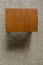 Top view of small teak table on beige carpet.