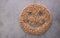 Top view of smile face made of pile of solid wood fuel pellets and placed on gray background