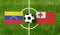Top view soccer ball with Venezuela vs. Tonga flags match on green football field