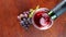 Top view of sommelier pour red wine from bottle to a wine glass on a wooden table.