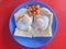 Top view a special breakfast of toast with half-put eggs and red beans on red background