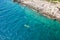 Top view of sportsmen or tourists kayaking in the turquoise transparent blue water of Adriatic sea rocky shore