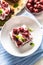 Top of view of a square piece of cherry pie with fresh cherries, mint and sour cream