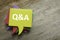 Top view stack of colorful speech bubbles with the top written with Q&A or questions and answers on wooden background