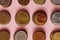 top view of stacks of coins from various countries on pink