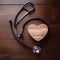 Top view a stethoscope placed on a table with a wooden heart-shaped sign. World Health Day