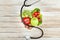 Top view of stethoscope,various organic vegetables and fruits on wooden surface