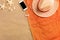 Top view straw hat and smartphone with copy space. Traveler accessories on sand