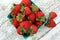Top view Strawberries in a green paper carton on white wood