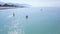Top view of surfers with paddles on background of turquoise sea and clear sky. Clip. People relax on sea riding SUP