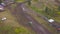 Top view of SUVs driving on country road. Clip. Off-road racing on mud roads in rural forest area