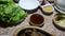 Top view of a table covered with Korean dishes. Sizzle pieces of meat, vegetable salads, a bowl of rice in a hot frying pan