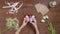 Top view of a table with items to create a composition for Easter. Women's hands knock eggs against each other and