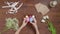 Top view of a table with items to create a composition for Easter. Women's hands knock eggs against each other and