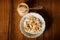 top view on tahini jar and bowl with oatmeal, bananas, spoon