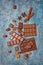 Top view of tasty broken chocolate bars with cocoa beans, nuts and spices