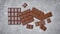 Top view of tasty broken chocolate bars on gray concrete background