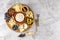 Top view of tasty charcuterie board with cheese, grape, nuts, olives, and ham on a circle kitchen plate