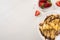 Top view of tasty crepes with chocolate spread and walnuts on plate near bowl with strawberries