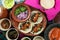 Top view of tasty tortillas with meat and tomato sauce next to a bowl of greens and onions